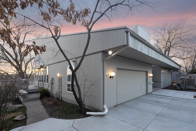 property exterior at dusk featuring concrete driveway and a garage