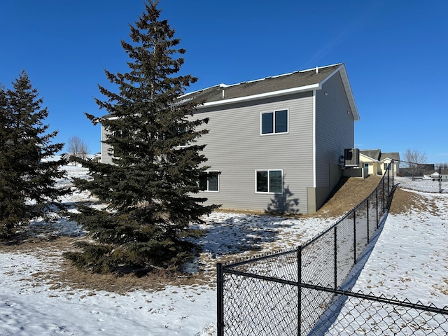 view of snowy exterior with central AC unit