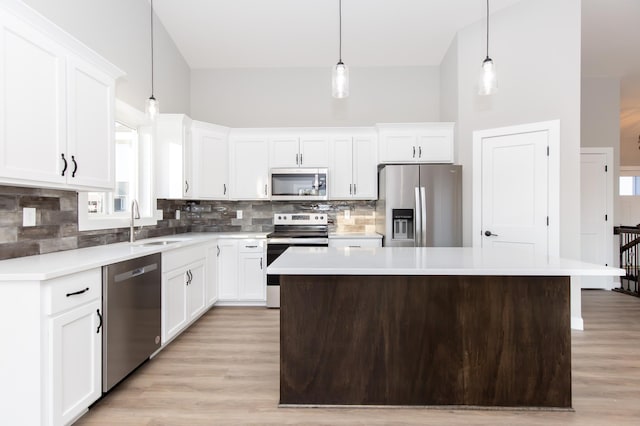 kitchen featuring pendant lighting, white cabinetry, appliances with stainless steel finishes, and a center island