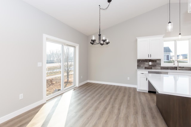 kitchen with white cabinetry, sink, stainless steel dishwasher, and lofted ceiling