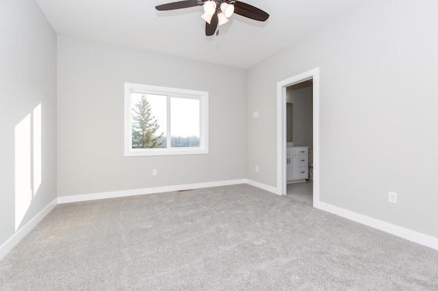 carpeted spare room featuring ceiling fan