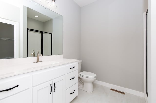 bathroom featuring tile patterned floors, vanity, toilet, and an enclosed shower