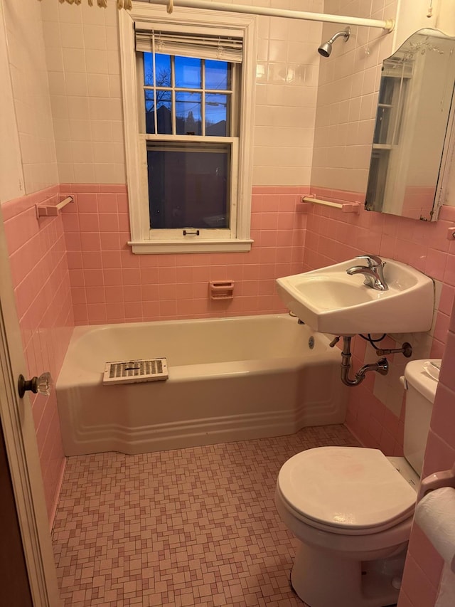 full bathroom featuring a sink, toilet, tile walls, and a bathtub