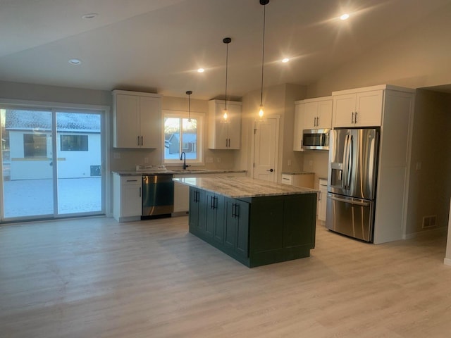 kitchen featuring white cabinetry, hanging light fixtures, a center island, light stone countertops, and appliances with stainless steel finishes