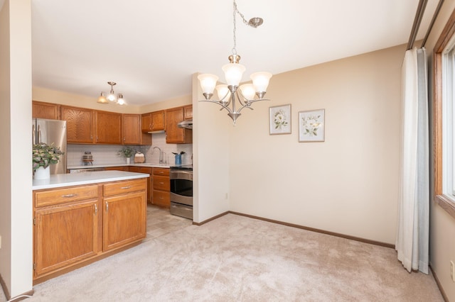 kitchen featuring light colored carpet, light countertops, appliances with stainless steel finishes, hanging light fixtures, and a notable chandelier