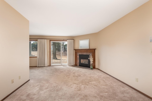 unfurnished living room featuring a fireplace, baseboards, and carpet