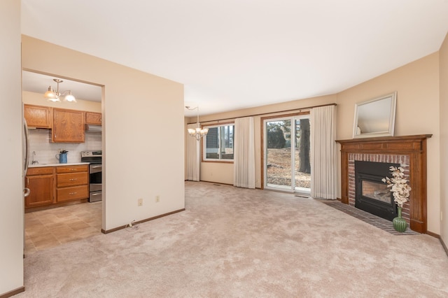 living area with baseboards, light carpet, a brick fireplace, and a chandelier