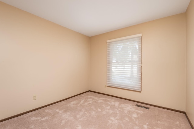 carpeted empty room with baseboards and visible vents