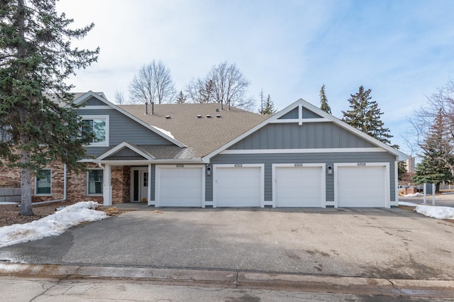 6964 Langford Ct, Edina, MN 55436 - view of property featuring roof with shingles, asphalt driveway, board and batten siding, and a garage