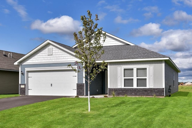 view of front of house featuring a shingled roof, a front lawn, driveway, stone siding, and an attached garage