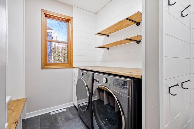 washroom with laundry area, visible vents, baseboards, and separate washer and dryer