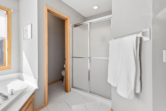 bathroom with toilet, marble finish floor, a shower stall, and baseboards