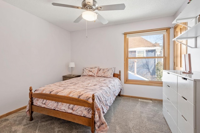 bedroom featuring dark colored carpet, a textured ceiling, and baseboards