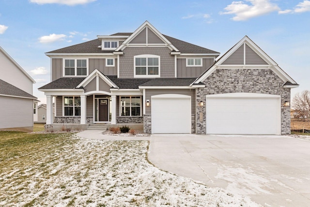 craftsman inspired home with a garage and covered porch