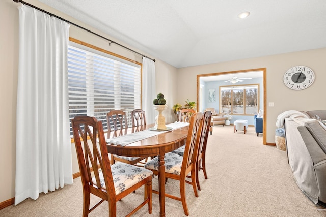 carpeted dining space with lofted ceiling