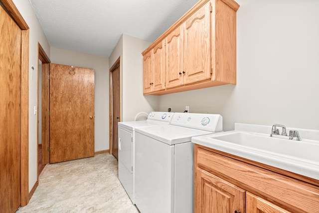 laundry area with a textured ceiling, cabinets, sink, and independent washer and dryer