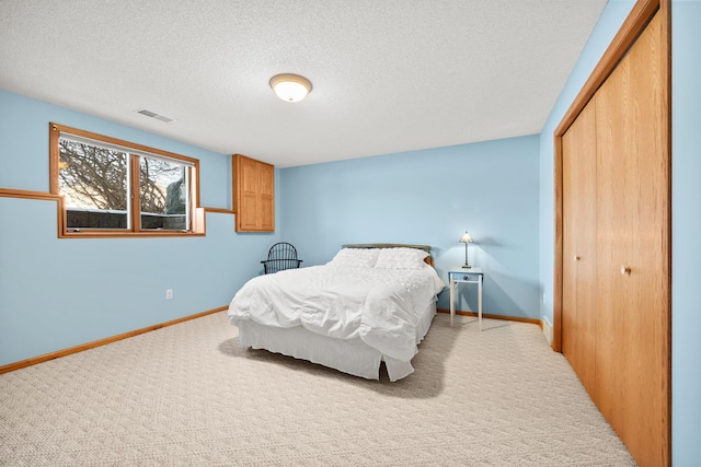 bedroom featuring carpet floors, a textured ceiling, and a closet