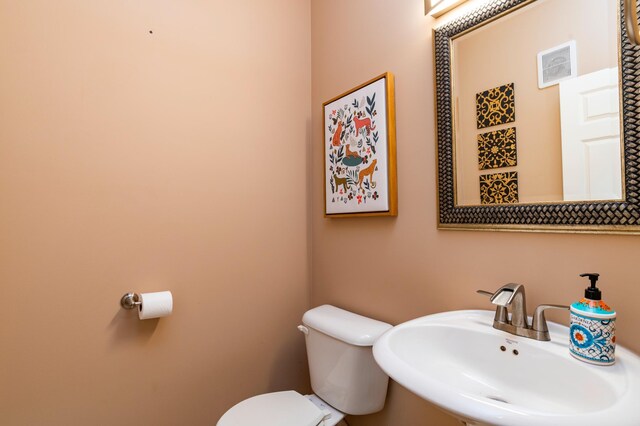 half bathroom featuring visible vents, a sink, and toilet