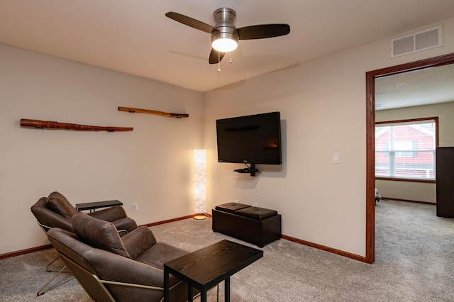 carpeted living room featuring visible vents, ceiling fan, and baseboards