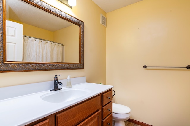 bathroom featuring visible vents, vanity, and toilet