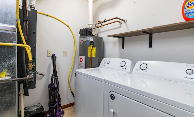 washroom featuring laundry area, water heater, and washing machine and clothes dryer