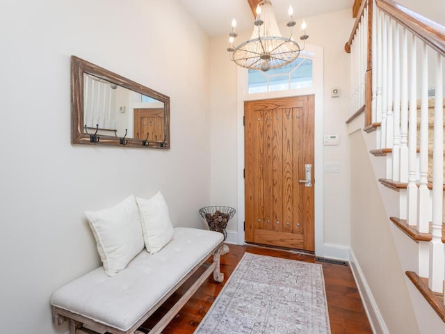 entryway featuring dark wood-style flooring, a notable chandelier, visible vents, baseboards, and stairs