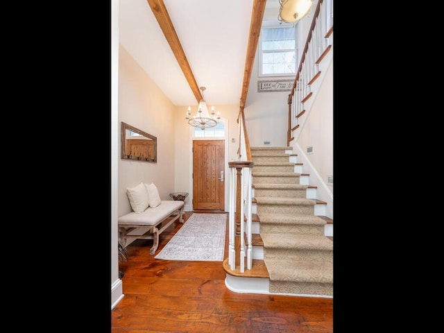 foyer entrance with beam ceiling, stairway, and wood finished floors