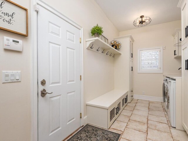 mudroom with washing machine and dryer and baseboards