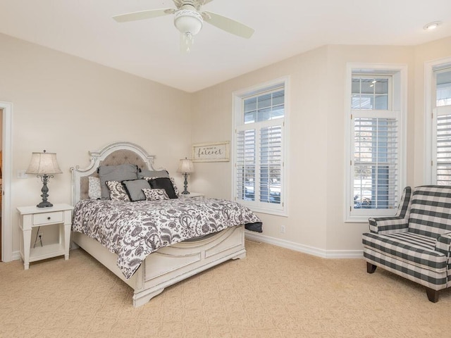 bedroom with baseboards, a ceiling fan, and light colored carpet