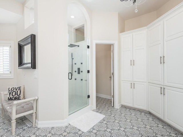 full bathroom featuring tile patterned flooring, a shower stall, and baseboards