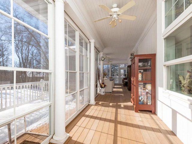 sunroom with decorative columns and a ceiling fan