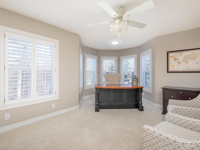 office featuring baseboards, ceiling fan, and light colored carpet