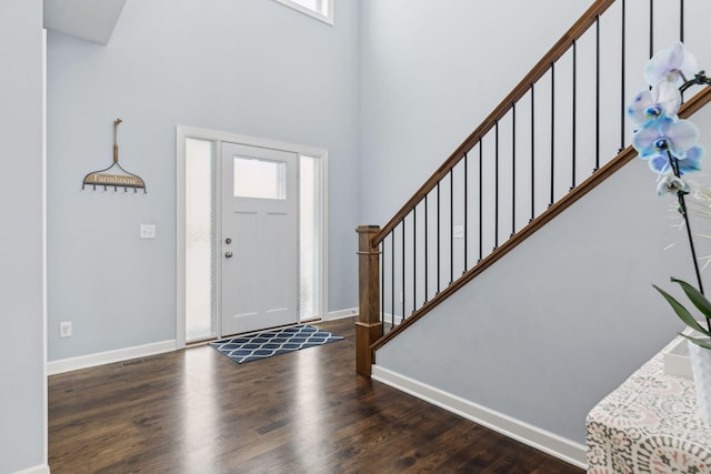 entrance foyer with a wealth of natural light, dark wood-type flooring, and a high ceiling