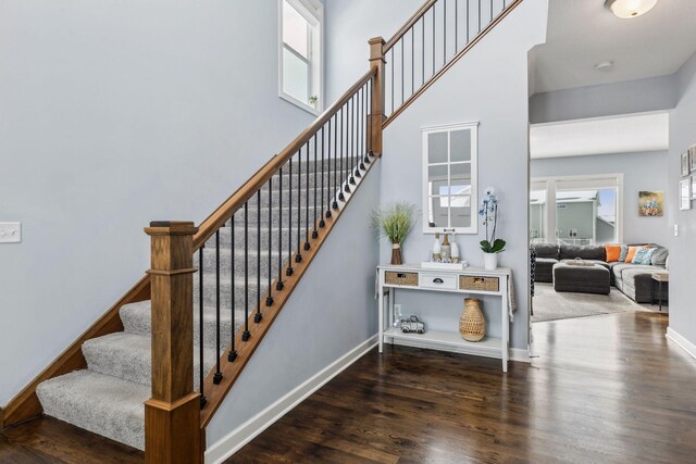 stairs with a high ceiling and hardwood / wood-style floors