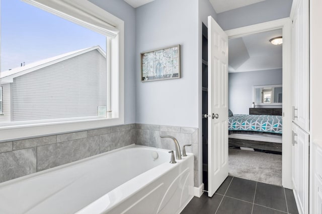 bathroom with tile patterned flooring and a tub