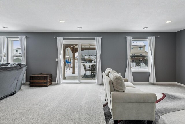 carpeted living room featuring plenty of natural light and a textured ceiling