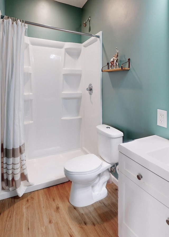 bathroom featuring hardwood / wood-style flooring, vanity, toilet, and walk in shower