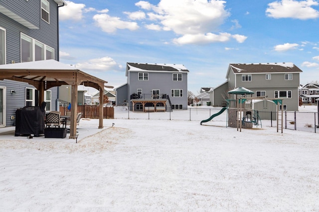 yard layered in snow with a playground and a gazebo