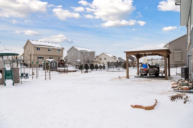 yard covered in snow featuring a playground and a gazebo