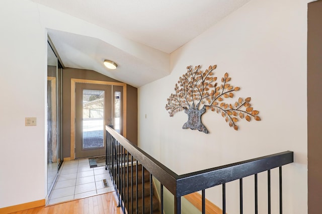 hallway with lofted ceiling and light hardwood / wood-style flooring