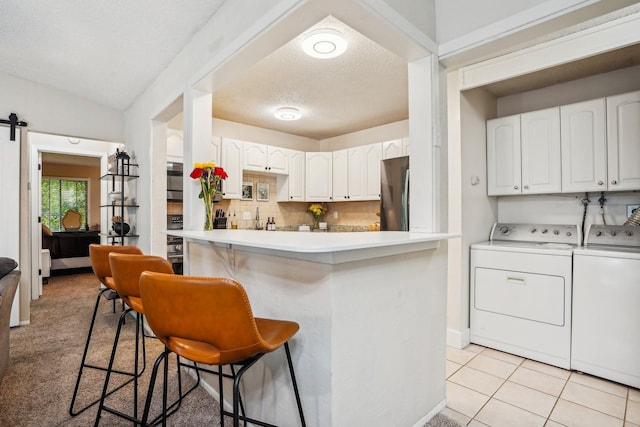 kitchen featuring white cabinetry, a kitchen bar, and kitchen peninsula