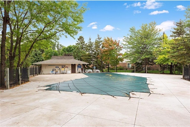 view of pool featuring an outbuilding and a patio