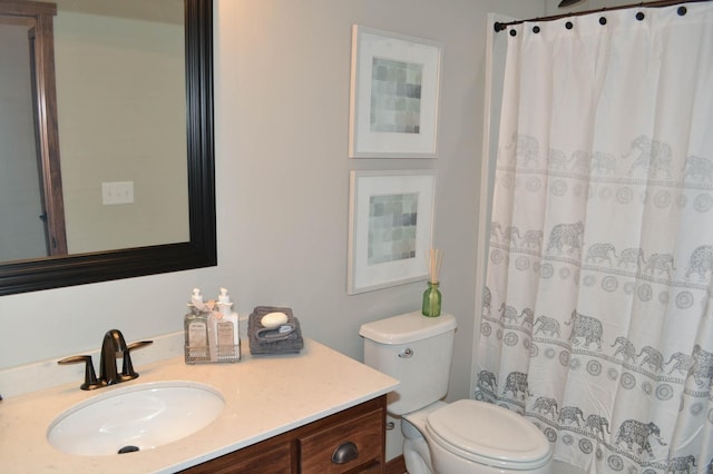 bathroom featuring toilet, a shower with shower curtain, and vanity