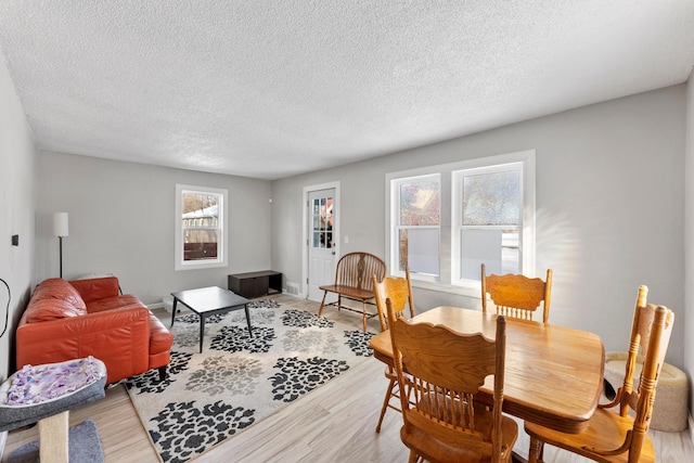 dining area featuring light hardwood / wood-style floors and a textured ceiling