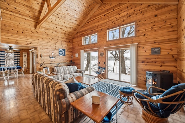 3313 Twin Island Cir NW, Prior Lake, MN 55372 - living room featuring high vaulted ceiling, a wood stove, wood walls, a ceiling fan, and a wooden ceiling with exposed beams