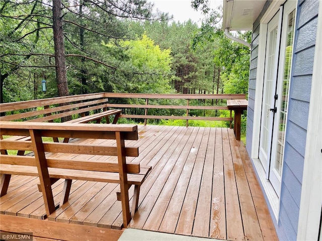 wooden deck with a wooded view