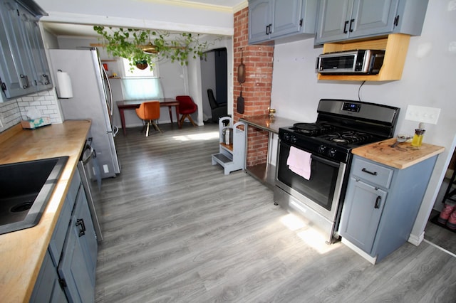 kitchen featuring light wood-type flooring, blue cabinetry, and stainless steel appliances