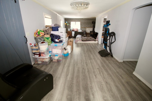 interior space featuring wood finished floors, an inviting chandelier, baseboards, and ornamental molding