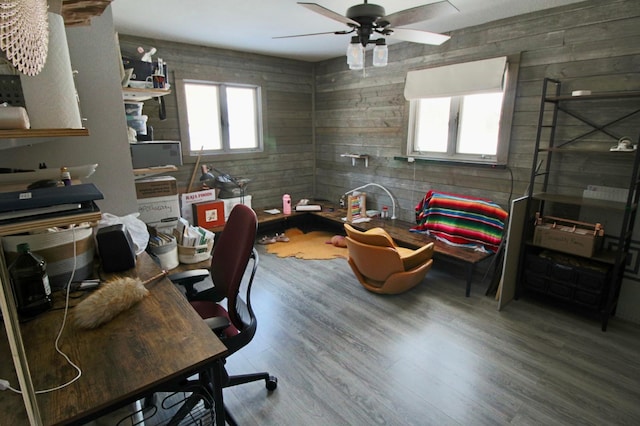 office featuring wood walls, wood finished floors, and ceiling fan