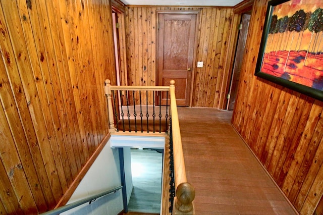 hallway with wooden walls and an upstairs landing